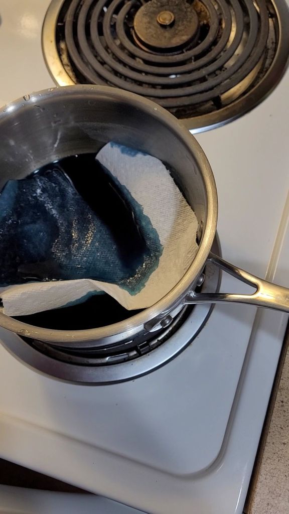 Soaking paper towels in butterfly pea flower tea
