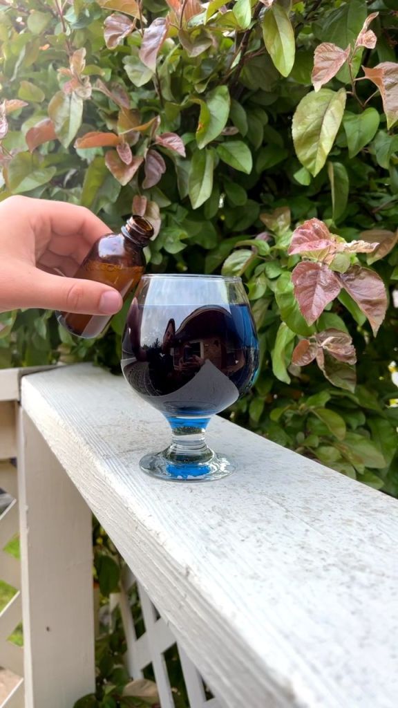 blue glass of tea sitting on a railing