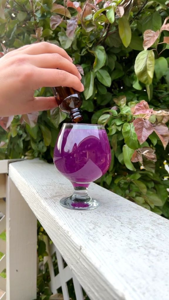 purple glass of tea sitting on a railing